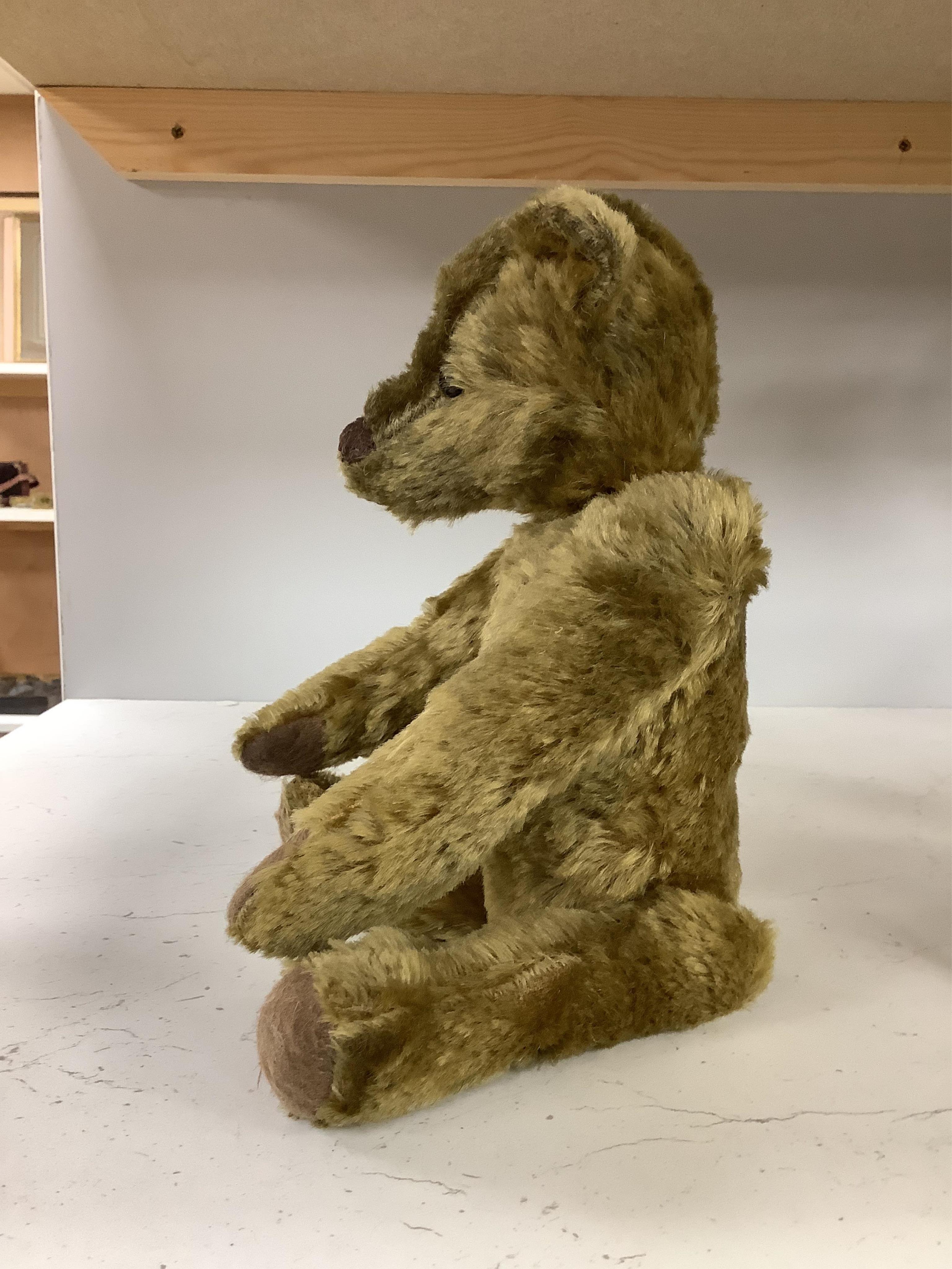 An early 20th century German hump backed plush teddy bear and three others, German teddy 30cm high. Condition - the German teddy has a short split on the back seam and glue on the front leg that needs removing and plush